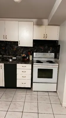 a kitchen with a white stove and white cabinets at Cozy private room in Brampton