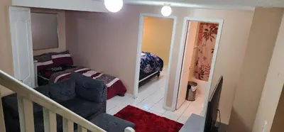 a living room with a couch and a bed at Cozy private room in Brampton