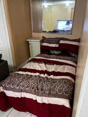 a bed in a small room with a mirror at Cozy private room in Brampton