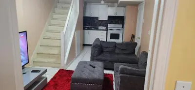 a living room with a couch and a kitchen at Cozy private room in Brampton
