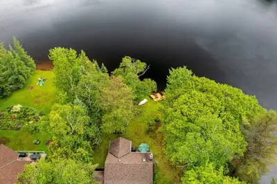 an aerial view of a house in the middle of a lake at Bear Essentials Hideaway in Huntsville