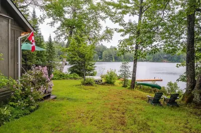 a backyard with a lake and a house at Bear Essentials Hideaway in Huntsville