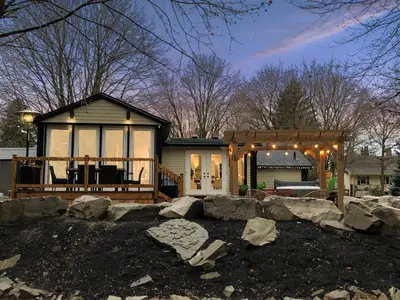 a home with a large deck and a house at Disconnect From Reality/ River House/Hot Tub/Pet Friendly in Port Burwell