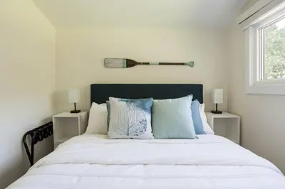 a bedroom with a large bed with white sheets and pillows at Disconnect From Reality/ River House/Hot Tub/Pet Friendly in Port Burwell