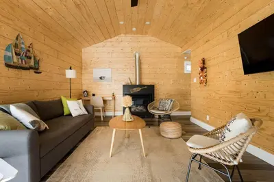a living room with a couch and a fireplace at Disconnect From Reality/ River House/Hot Tub/Pet Friendly in Port Burwell