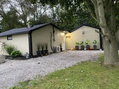a house with a garage with plants in it at Disconnect From Reality/ River House/Hot Tub/Pet Friendly in Port Burwell