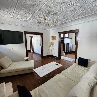 a living room with a couch and a tv at The Pandora Century Home in Kitchener