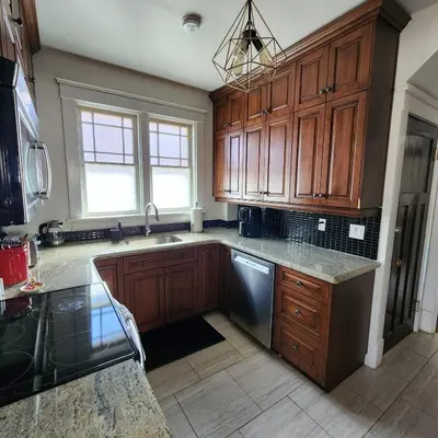 a kitchen with wooden cabinets and stainless steel appliances at The Pandora Century Home in Kitchener