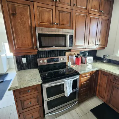 a kitchen with wooden cabinets and a stove top oven at The Pandora Century Home in Kitchener
