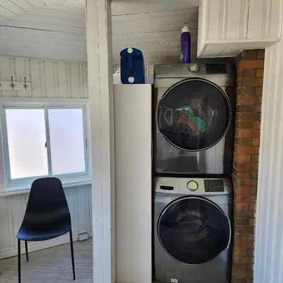a washer and dryer sitting next to a window at The Pandora Century Home in Kitchener