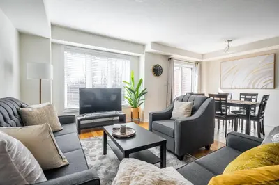 a living room with couches and a television and a table at GlobalStay 3 Bedroom Townhouse Near Niagara Falls Brock University in Thorold