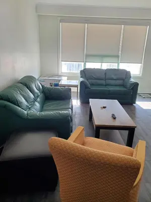 a living room with a couch and a table and chairs at Maxwell Esabu in Toronto