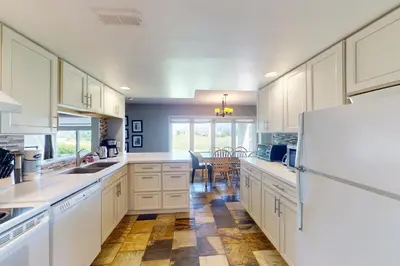 a kitchen with white cabinets and a white refrigerator at Wintergreen 125 in Blue Mountains