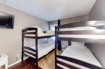 two bunk beds in a room with a tv at Wintergreen 116 in Blue Mountains