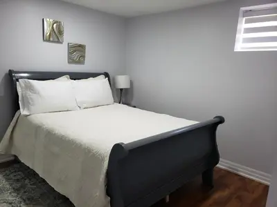 a bedroom with a bed with white sheets and a window at Luxurious Apt 2BRs-1BA Spacious Modern, with free parking in Brampton