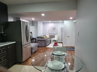 a kitchen and living room with a glass table at Luxurious Apt 2BRs-1BA Spacious Modern, with free parking in Brampton