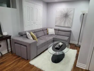 a living room with a couch and a glass table at Luxurious Apt 2BRs-1BA Spacious Modern, with free parking in Brampton