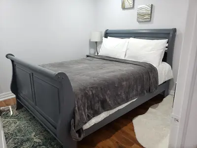 a black bed with white pillows in a room at Luxurious Apt 2BRs-1BA Spacious Modern, with free parking in Brampton