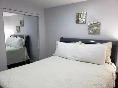a bedroom with a bed with white pillows and a mirror at Luxurious 1BR-1BA Apartment Bright Spacious with free parking-gc-1 in Brampton
