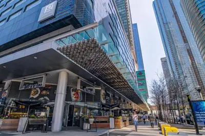 a building in a city with people walking in the street at Stunning 2 BD in heart of Toronto with Parking in Toronto