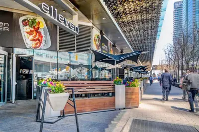 a food store on a street with people walking in front of it at Stunning 2 BD in heart of Toronto with Parking in Toronto