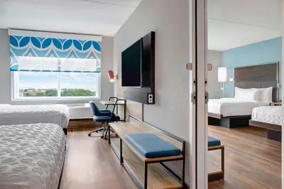 a hotel room with two beds and a desk and a television at Tru By Hilton Toronto Airport West in Mississauga