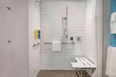 a bathroom with a shower with white tiles at Tru By Hilton Toronto Airport West in Mississauga