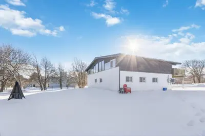 a house in the snow with the sun behind it at Semi Detached Mountain View Chalet in Blue Mountains