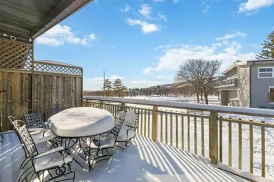a patio with a table and chairs on a snowy deck at Semi Detached Mountain View Chalet in Blue Mountains
