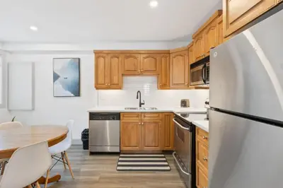 a kitchen with wooden cabinets and a table and a refrigerator at Collingwood Chalet Near Blue Mountain Slopes 39A in Collingwood
