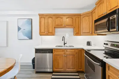 a kitchen with wooden cabinets and stainless steel appliances at Collingwood Chalet Near Blue Mountain Slopes 39A in Collingwood
