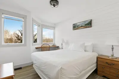 a white bedroom with a bed and two windows at Collingwood Chalet Near Blue Mountain Slopes 39A in Collingwood
