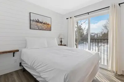a white bedroom with a bed and a window at Collingwood Chalet Near Blue Mountain Slopes 39B in Collingwood