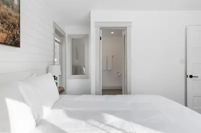 a white bedroom with a large bed with white sheets at Collingwood Chalet Near Blue Mountain Slopes 39B in Collingwood