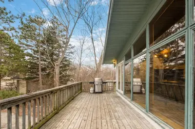 a porch of a house with a wooden deck at 3 Level Ski Chalet 7BR w Deck, Sauna & Ping-Pong! in Blue Mountains
