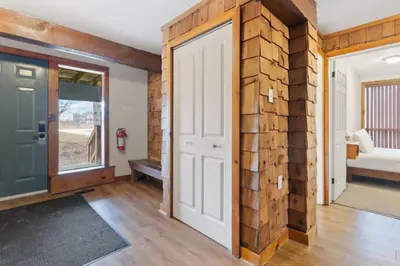 an open door in a room with a brick wall at 3 Level Ski Chalet 7BR w Deck, Sauna & Ping-Pong! in Blue Mountains
