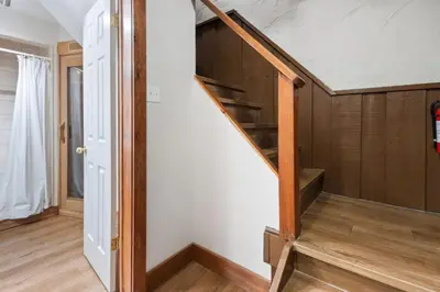 a stairwell in a house with a wooden stair case at 3 Level Ski Chalet 7BR w Deck, Sauna & Ping-Pong! in Blue Mountains