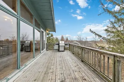 a large deck with a view of the water at 3 Level Ski Chalet 7BR w Deck, Sauna & Ping-Pong! in Blue Mountains