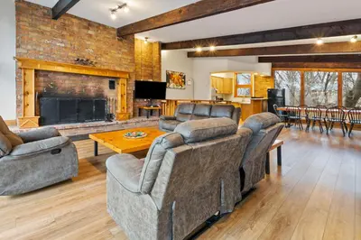 a living room with two couches and a fireplace at 3 Level Ski Chalet 7BR w Deck, Sauna & Ping-Pong! in Blue Mountains