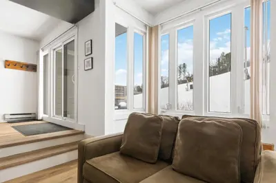 a living room with a couch and windows at Blue Mountain Ski In Ski Out Resort Condo 2 Level in Blue Mountains