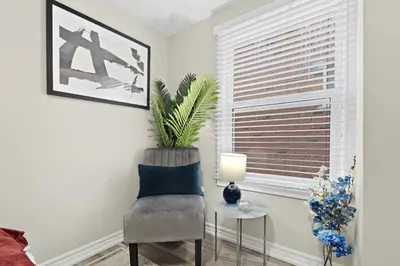 a living room with a chair and a table at Separate 3BR Family Friendly Apartments, Separate Floors, 5 Minutes Walk to The Fallsview with Free Parking & Wine in Niagara Falls