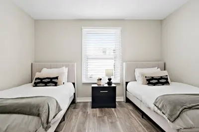 two beds sitting next to each other in a bedroom at Separate 3BR Family Friendly Apartments, Separate Floors, 5 Minutes Walk to The Fallsview with Free Parking & Wine in Niagara Falls