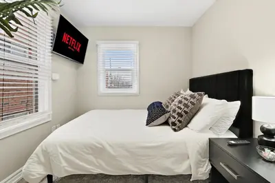 a bedroom with a bed with white sheets and pillows at Separate 3BR Family Friendly Apartments, Separate Floors, 5 Minutes Walk to The Fallsview with Free Parking & Wine in Niagara Falls
