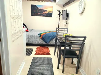 a room with a table and chairs and a bed at Cozy & Convenient Studio Apartment in Pickering