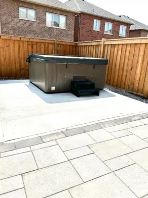 a hot tub in a backyard next to a wooden fence at Family Friendly - HOT TUB - Near Toronto & UOIT in Oshawa
