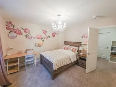 a bedroom with a bed and a desk and a chandelier at Inspired Stay close to Niagara *4B & 2King Beds* in Thorold