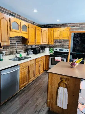 a kitchen with wooden cabinets and stainless steel appliances at Casa Maria Irena in Meaford