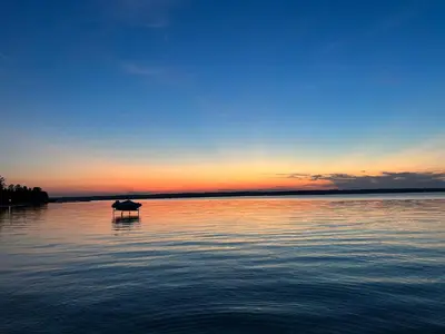 a horse standing in the middle of a lake at sunset at Casa Maria Irena in Meaford