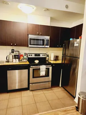 a kitchen with a stainless steel stove and refrigerator at Beautiful Townhouse Near Yorkdale Mall, Wilson Subway in Toronto