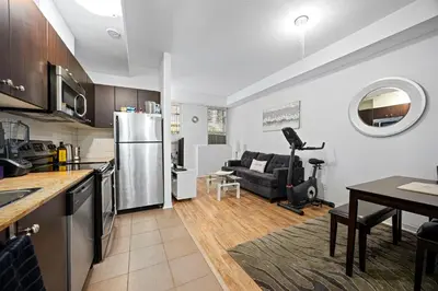 a kitchen and living room with a refrigerator and a table at Beautiful Townhouse Near Yorkdale Mall, Wilson Subway in Toronto
